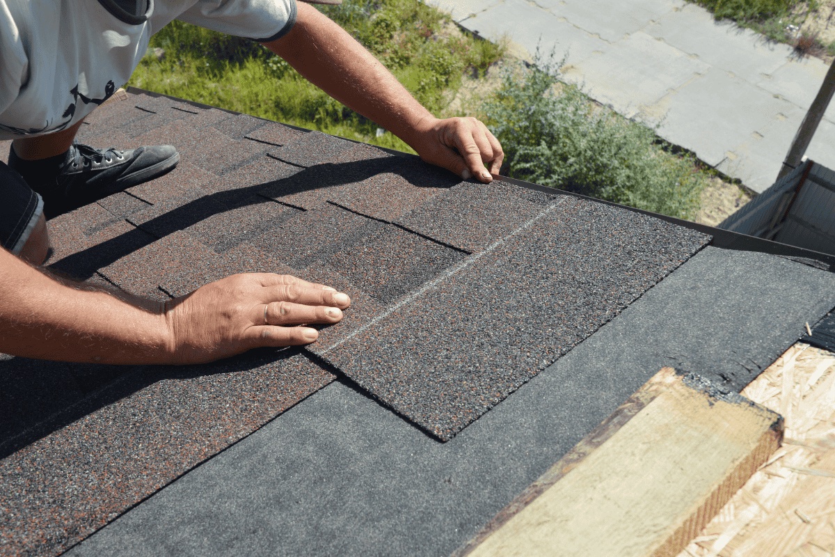 Roofer installing asphalt shingles